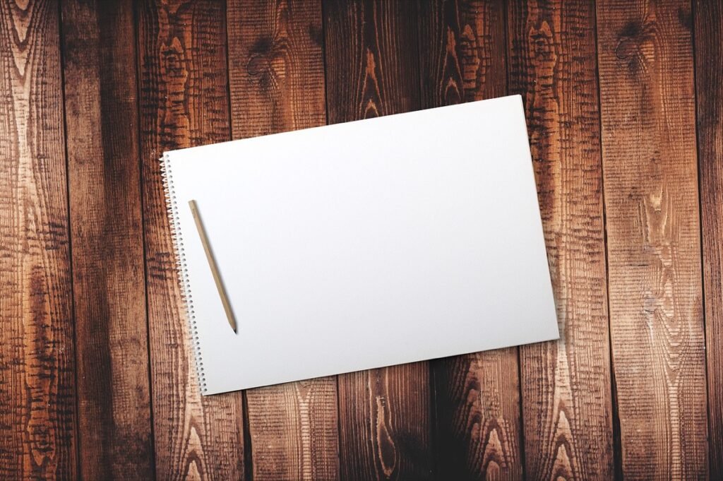 Blank notepad and pencil on a wooden table