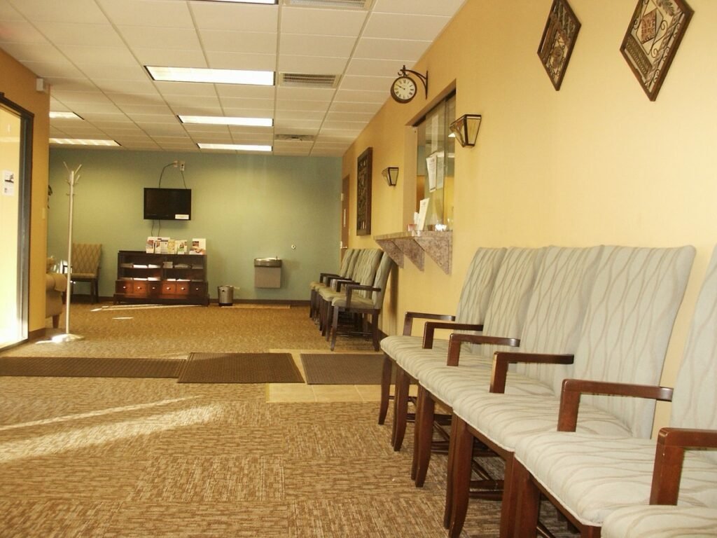 Empty clinic waiting room with a row of chairs